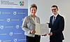 NRW Science Minister Ina Brandes presents Prof. Ulf-Peter Apfel with the funding notification